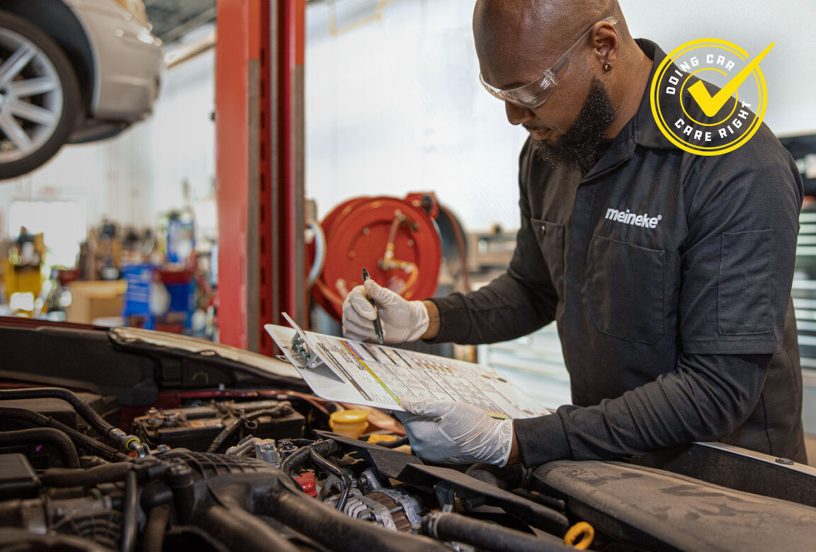 Meineke technician completing a multi-point inspection checklist